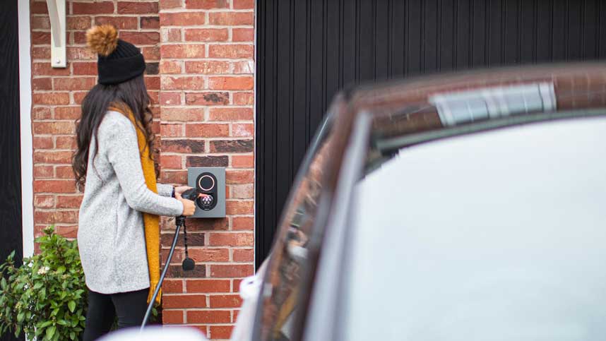 Woman Charging EV Using Shared Charger
